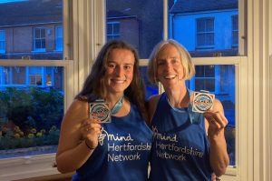 Fundraisers holding up medals from Cheltenham marathon