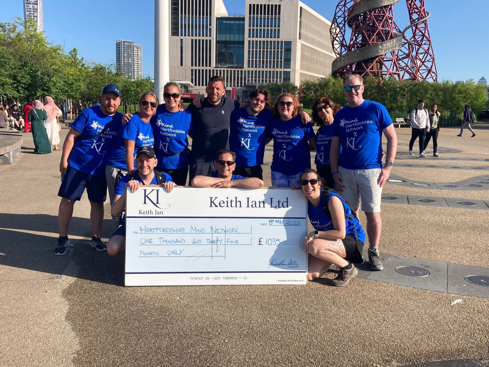 the photo shows 11 fundraisers from the Keith Ian Estate Agents standing outside next to a giant cheque