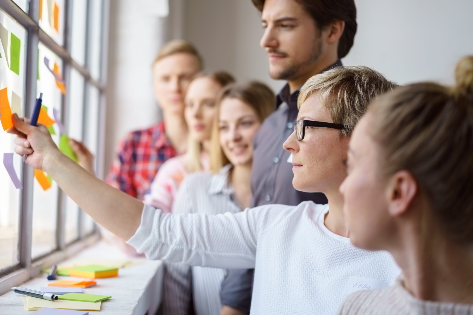 A group of people looking at post-it notes in a training session