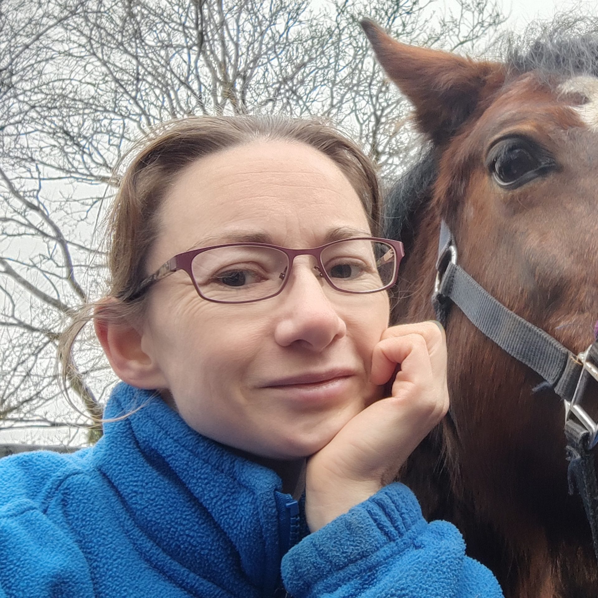 The photo shows our staff member Jenny stood with a horse, she is smiling at the camera